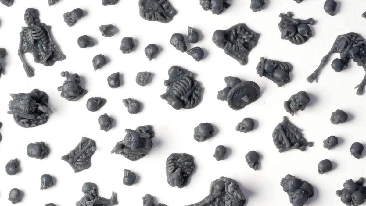 Unpainted grey resin skulls, bones and skeleton pieces from Gamers Grass Basing Bits