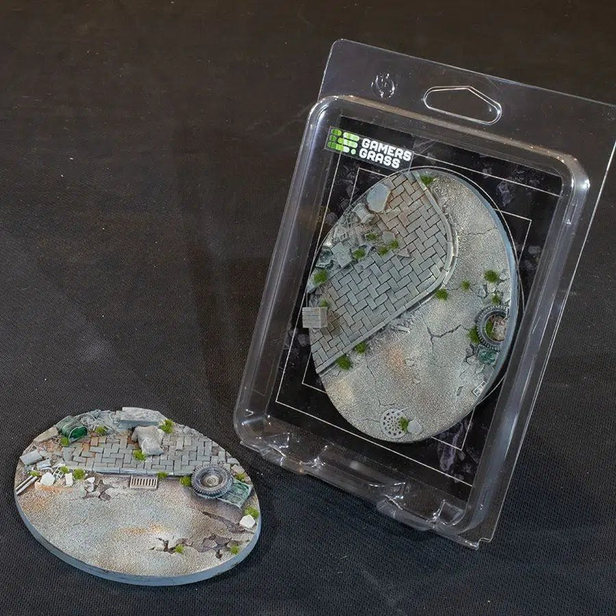 Gamers Grass Battle Ready Urban Warfare 120mm oval base with broken paving and rubble, beside its blister