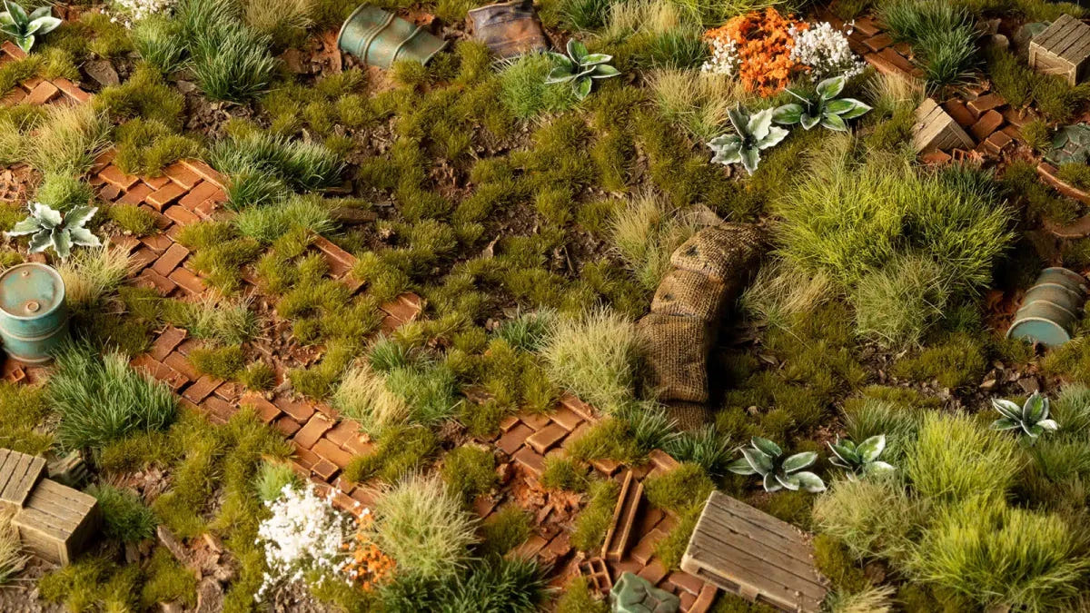 Terrain board scattered with Gamers Grass Dry Green tufts among ruins and crates