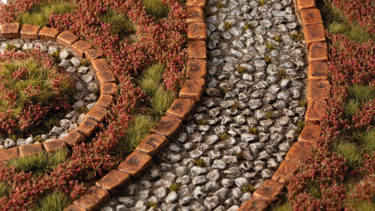 Gamers Grass Red Camellia Flowers tufts lining a cobbled path in a scenic diorama