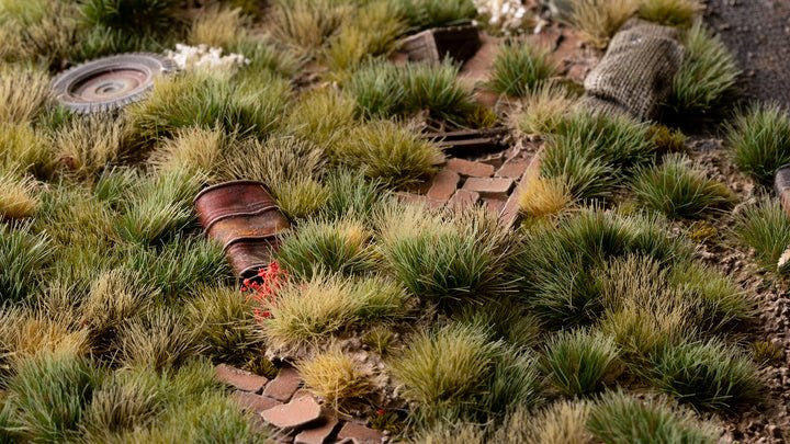 Gamers Grass Strong Green 6mm tufts used on a scenic battlefield base among rubble and debris