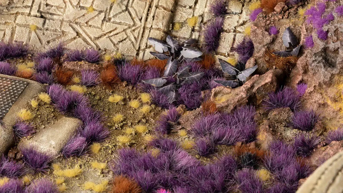 Gamers Grass Alien Purple 6mm tufts on a painted scenic base among paving stones and rocks