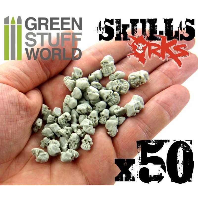 Handful of fifty Green Stuff World resin Ork skulls in an open palm to show their size