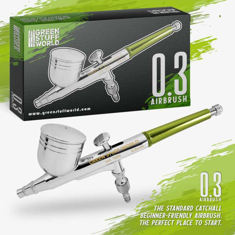 Green Stuff World 0.3mm airbrush in front of its green and black retail box