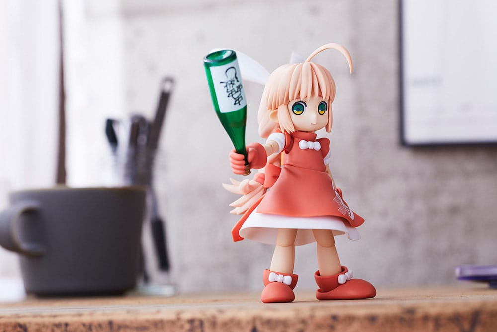 HoiHoi-san Heavy Arms kit holding a green bottle on a desk next to a mug