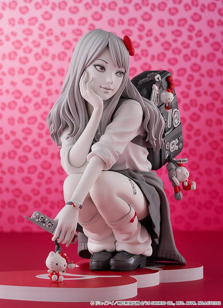Junji Ito Gyaru Tomie figure with red bow and Hello Kitty charms on a pink leopard-print backdrop