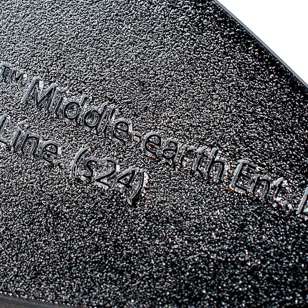 Close-up of the Middle-earth Enterprises licence text stamped on the brooch back