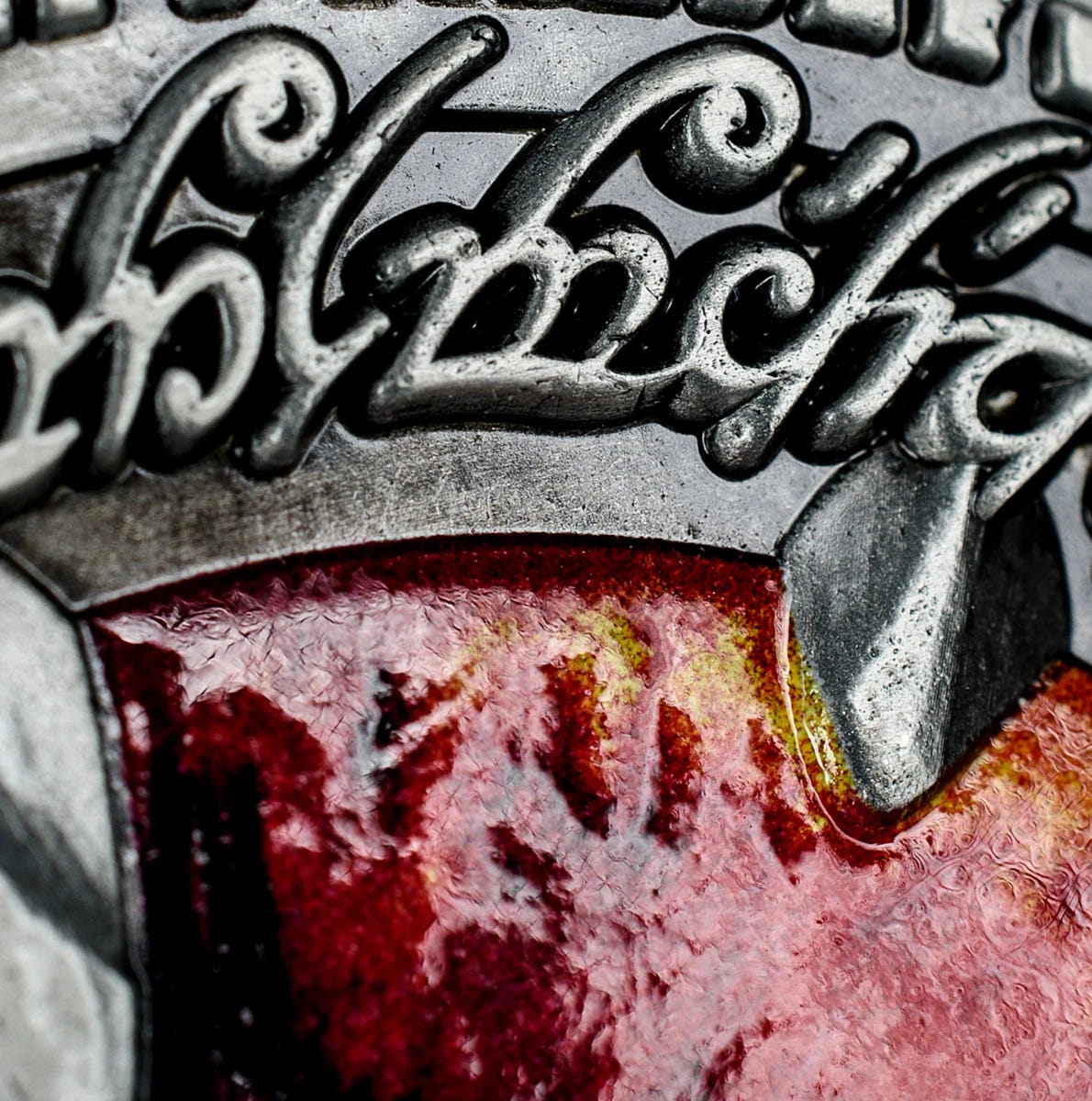 Close-up of Elvish lettering and red enamel on the Lord of the Rings Deluxe Coin