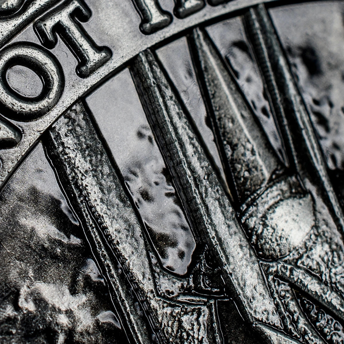 Macro close-up of the spiked crown and lettering on the Eye of Sauron coin reverse