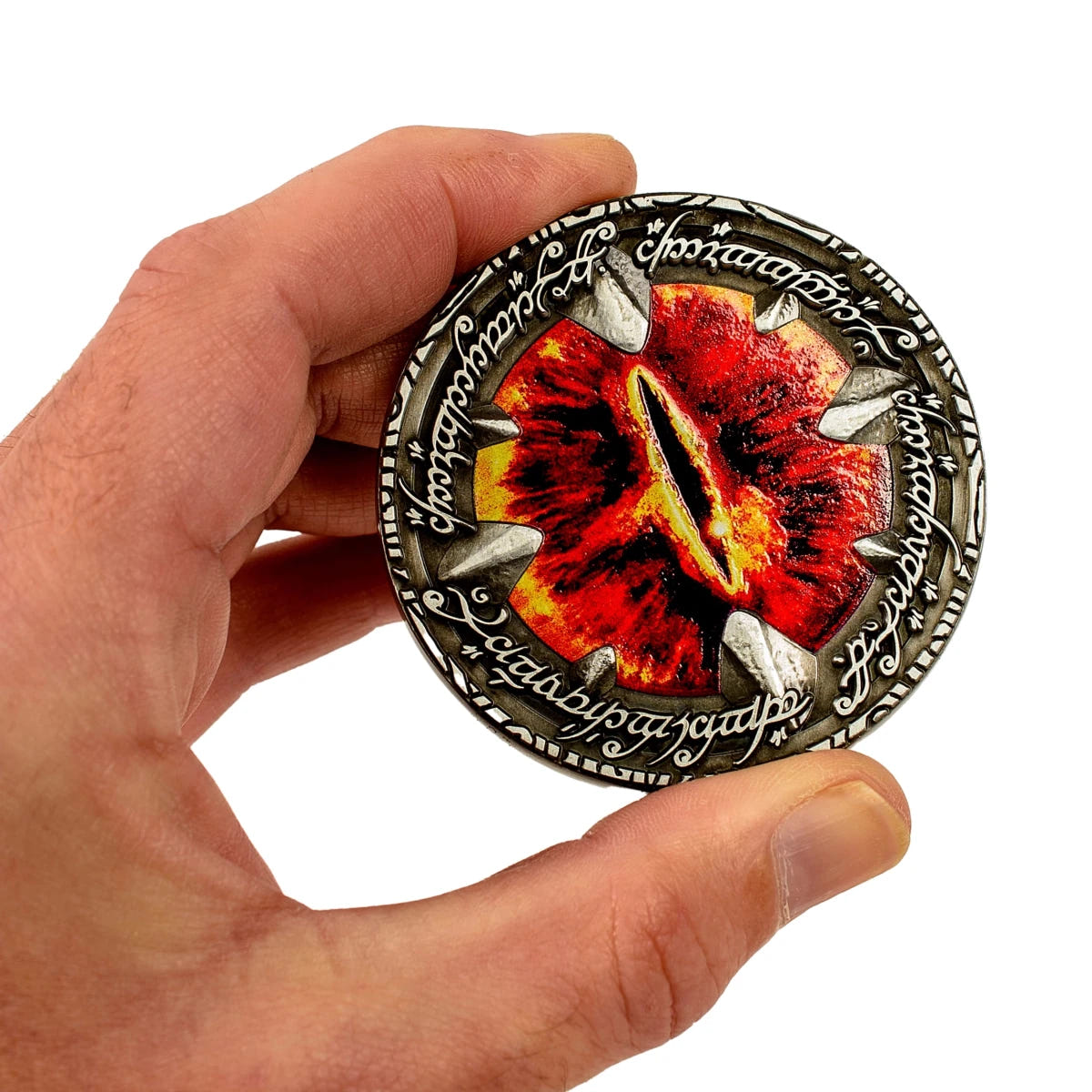 Eye of Sauron Deluxe Coin held between fingers, showing its thickness and raised claws
