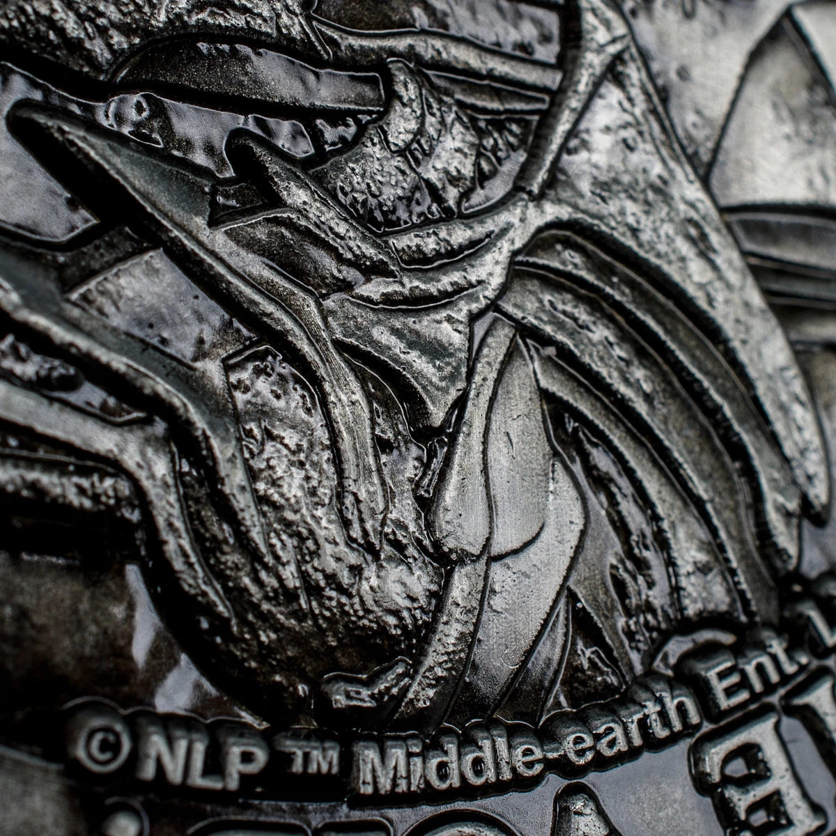 Macro detail of Sauron's gauntlet and the copyright line on the coin reverse