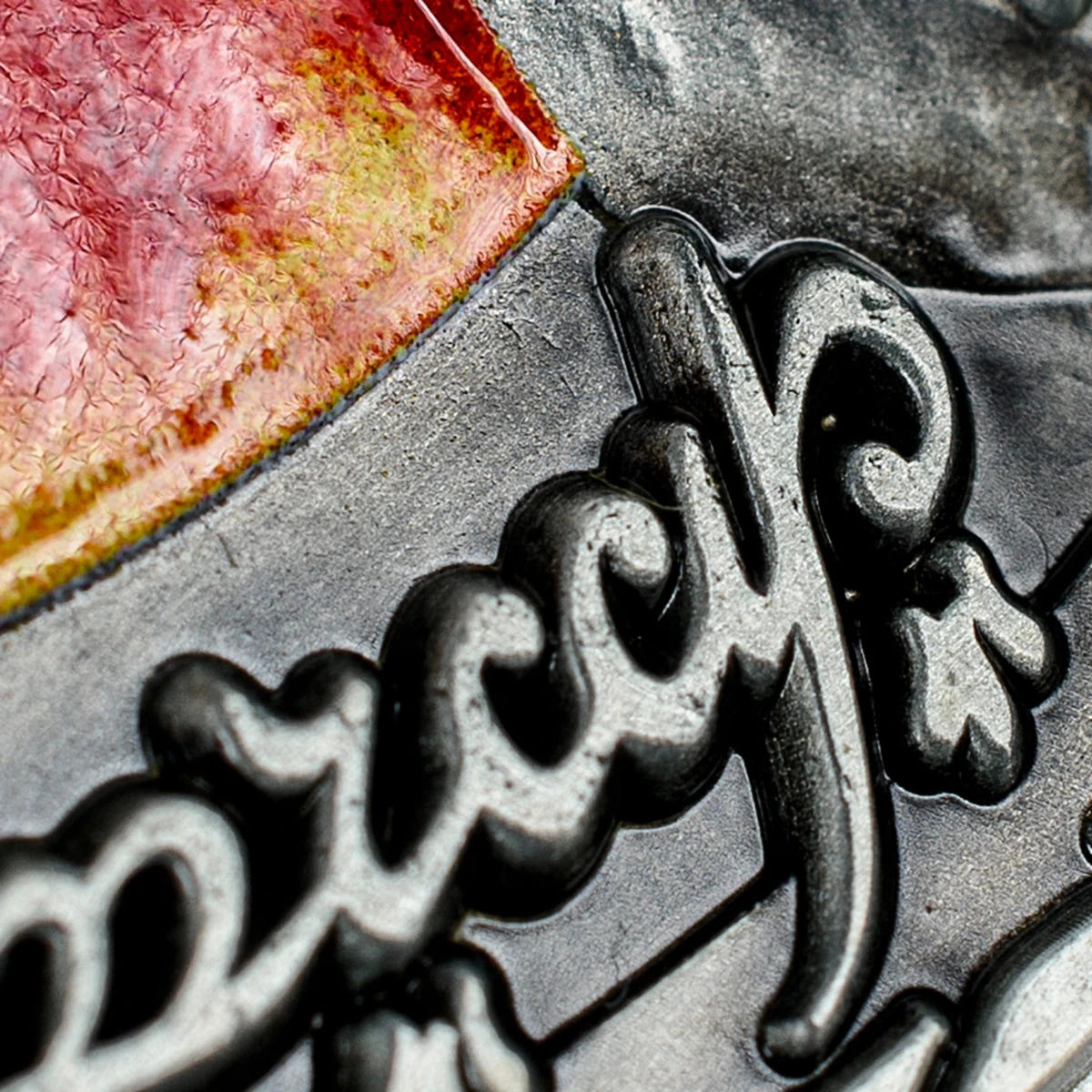 Macro close-up of the Elvish script border beside the glossy red enamel eye