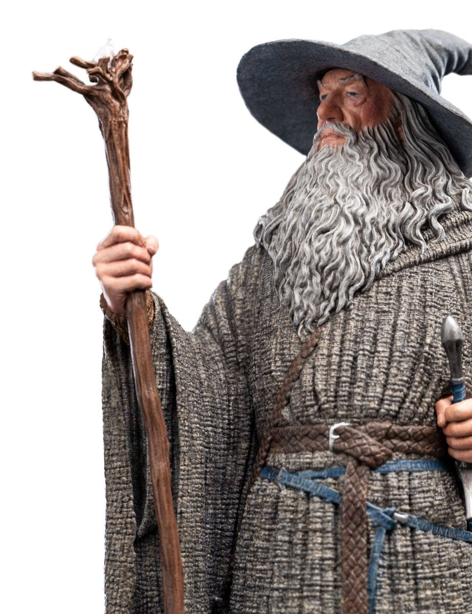 Close-up of Gandalf the Grey statue's bearded face, hat and wooden staff