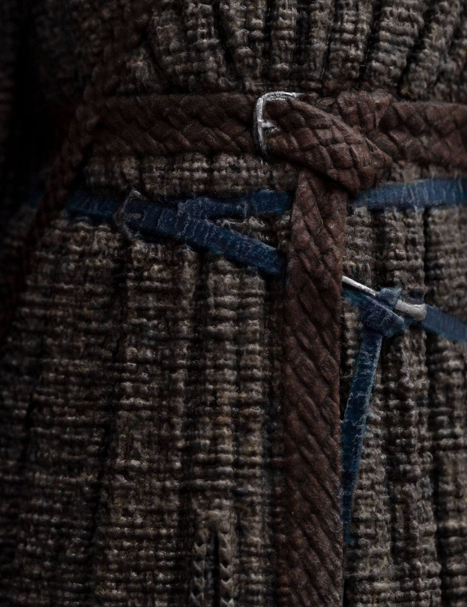 Close-up of Gandalf the Grey statue's textured robe and braided leather belt