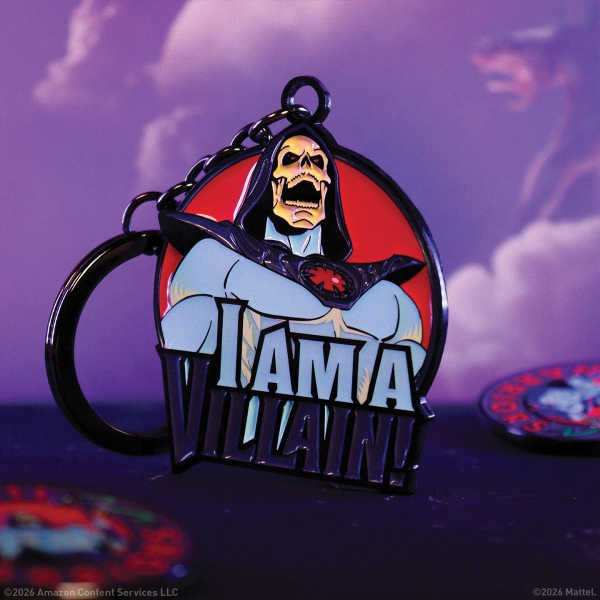 Skeletor "I Am a Villain!" enamel keyring close-up on a purple backdrop