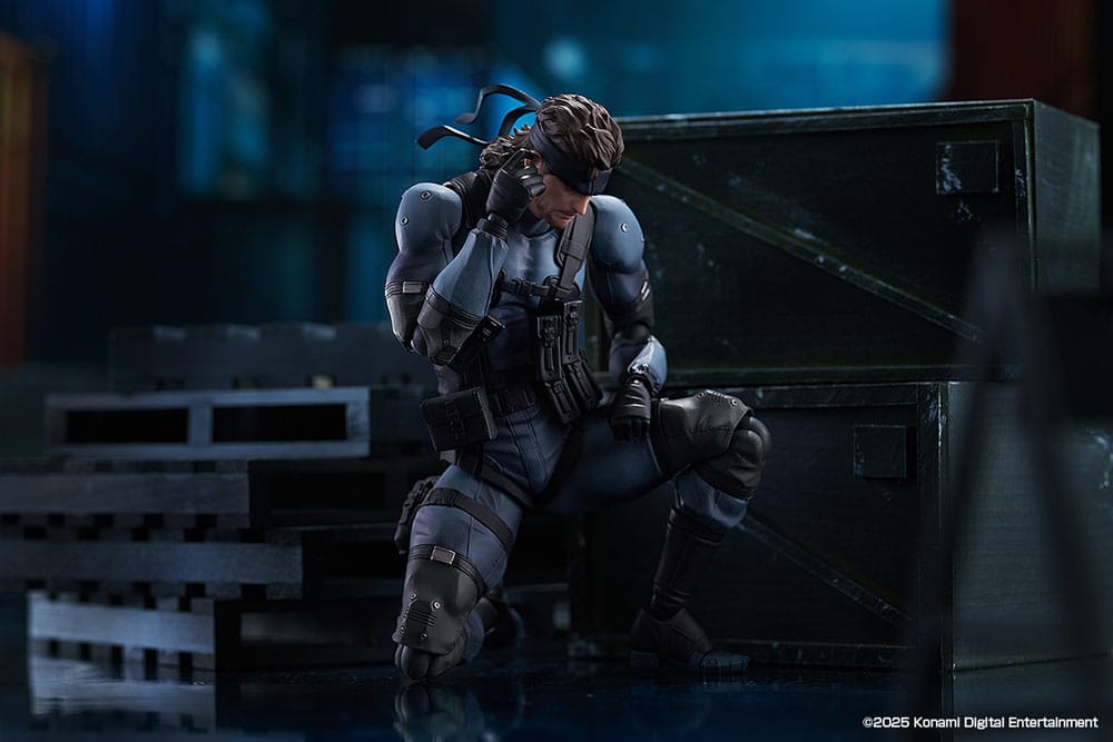 figma Solid Snake crouching behind crates in a dark warehouse scene