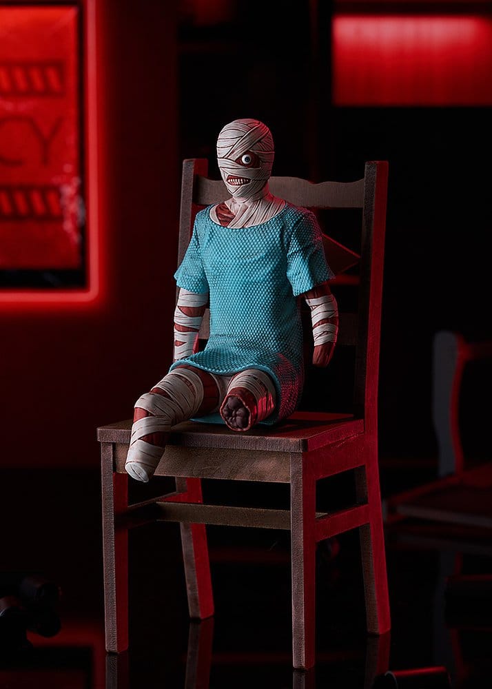 Mouthwashing Curly sitting figure perched on a wooden chair in a red-lit room, chair not included