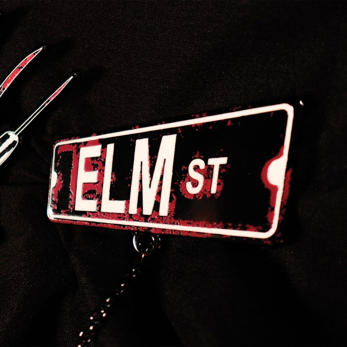 Close-up of the Elm St street sign enamel pin from the Nightmare on Elm Street set