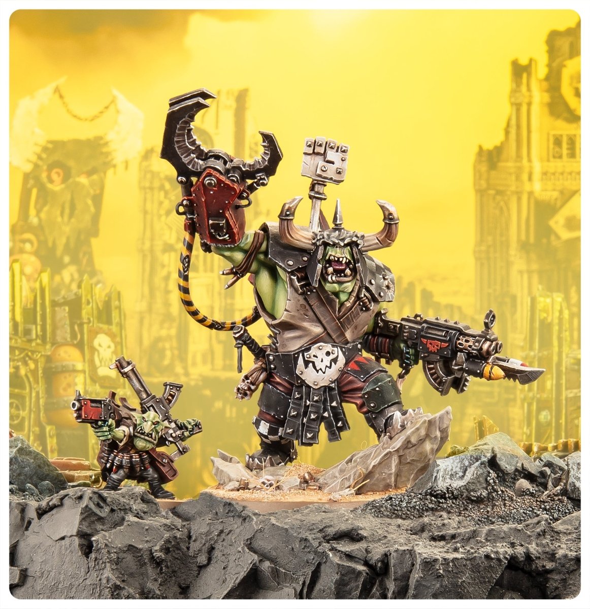 Painted Ork Warboss and ammo grot on a rocky battlefield in front of a yellow ruined city