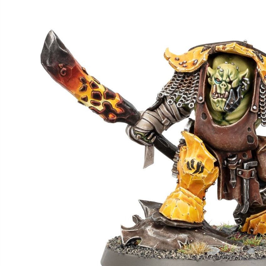 Close-up of Zoggrok Anvilsmasha's face, chainmail hood and flame-patterned blade