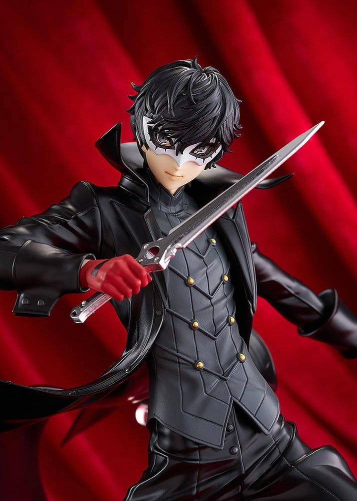 Close-up of Joker figure's white mask, red gloves and raised dagger, red curtain backdrop