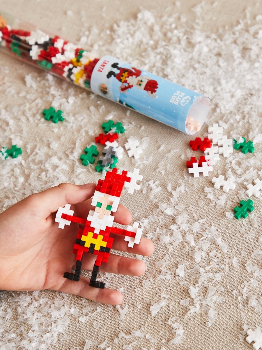 Plus-Plus Santa build held in a hand with the tube behind