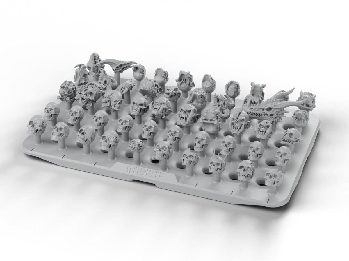 QTRMSTR Skull Pile – 50 mixed resin skulls on a snap-pin tile