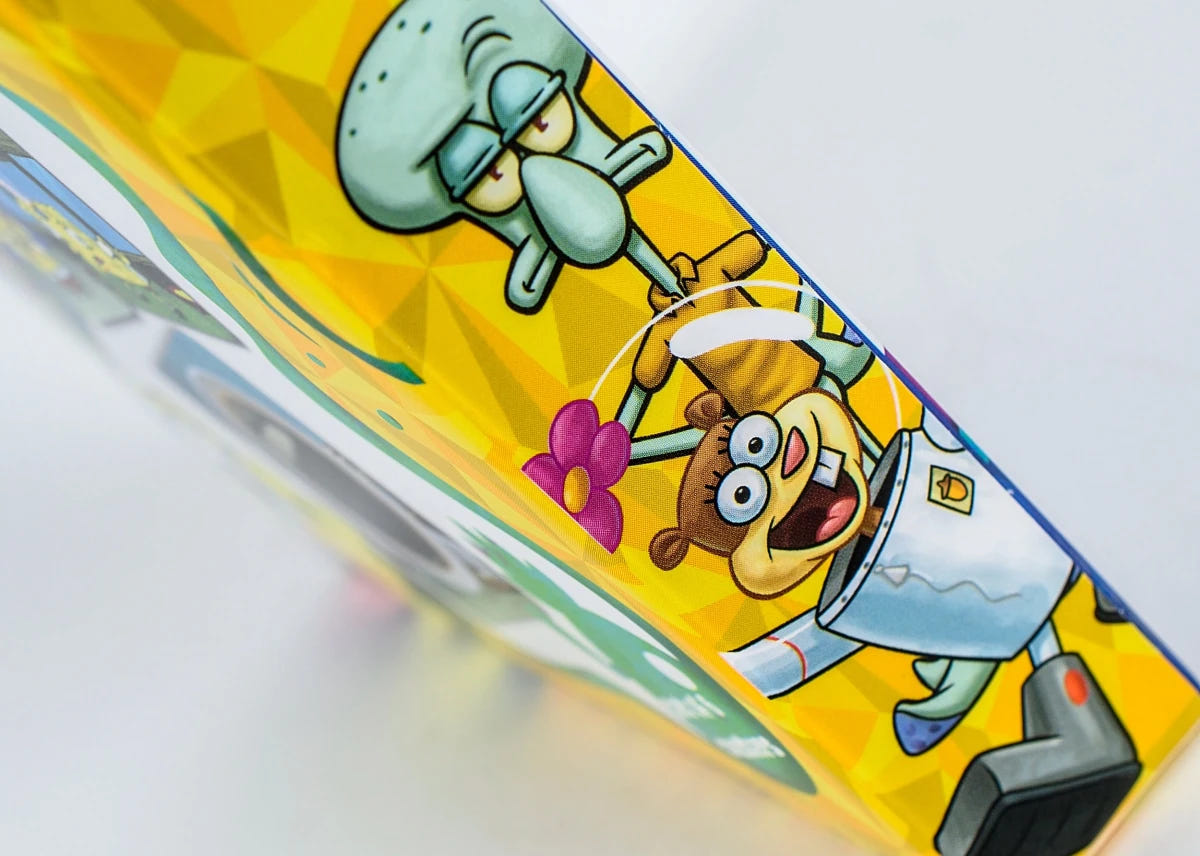 Close-up of the SpongeBob Meme Coasters box side showing Squidward and Sandy artwork