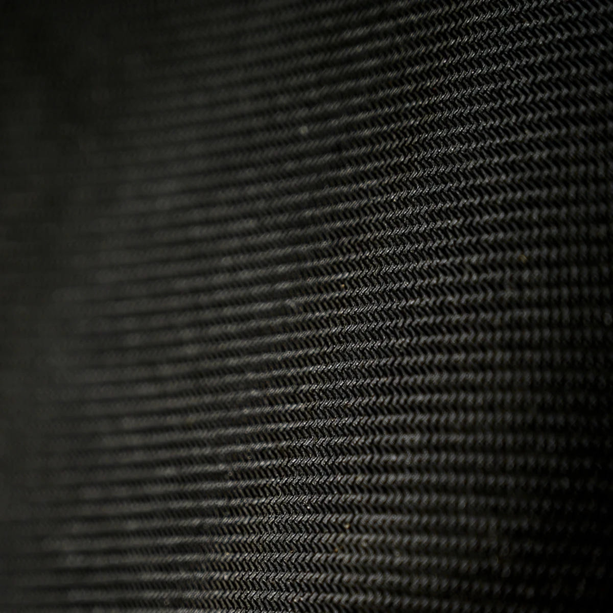 Close-up of the black textured fabric surface of the Horus Heresy Traitor Legion desk mat