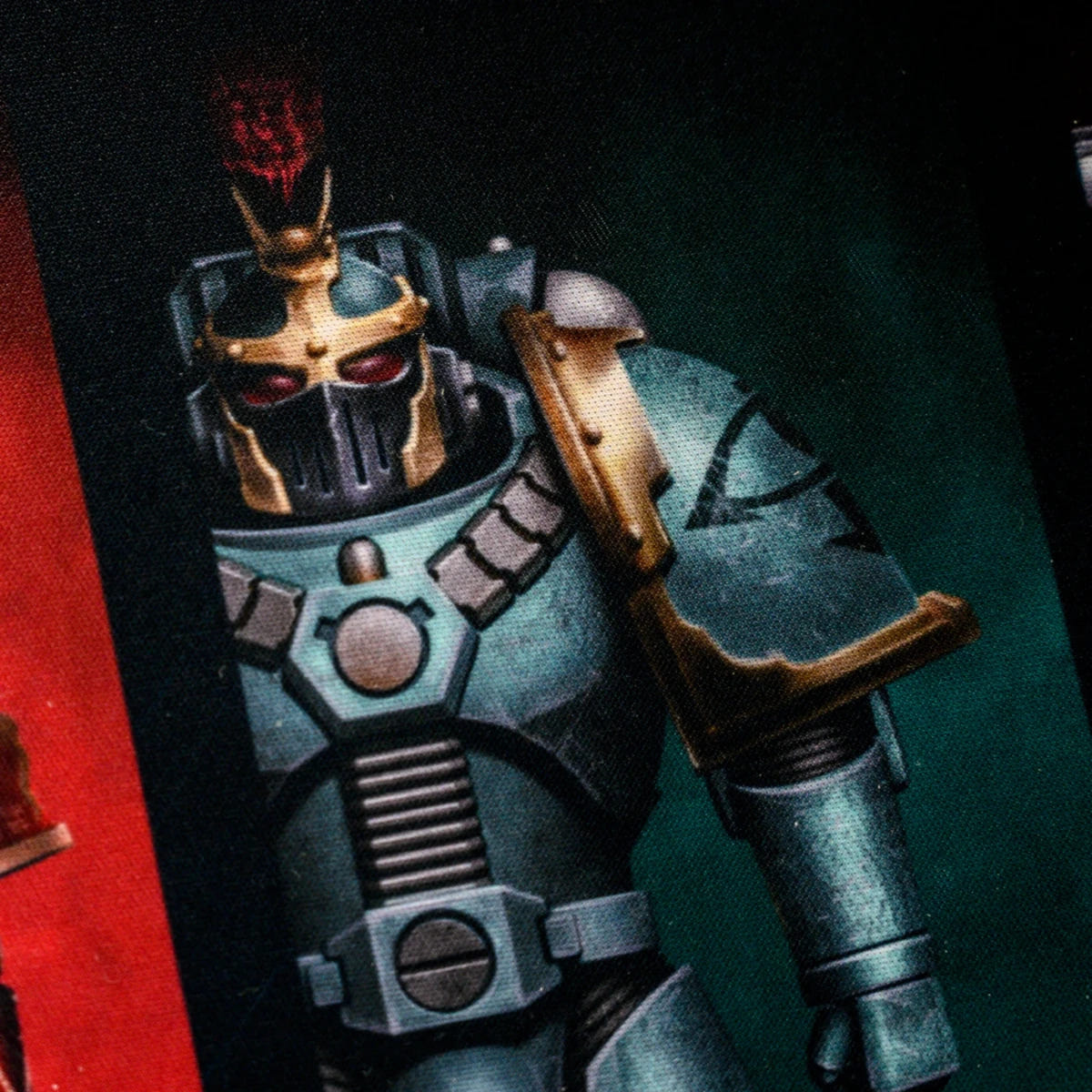 Close-up of a teal armoured Space Marine with gold helmet printed on the Traitor Legion desk mat