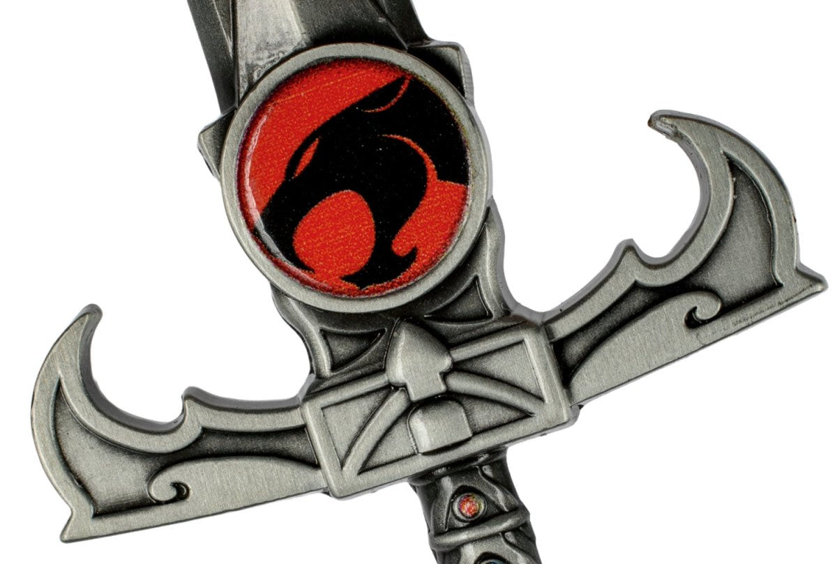 Close-up of the red Eye of Thundera emblem on the Sword of Omens bottle opener hilt