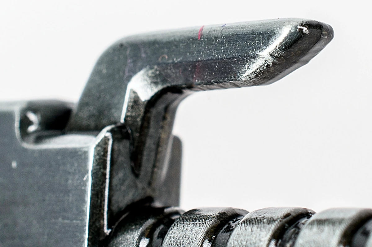 Close-up of the chainsword bottle opener's hooked guard used to lift caps
