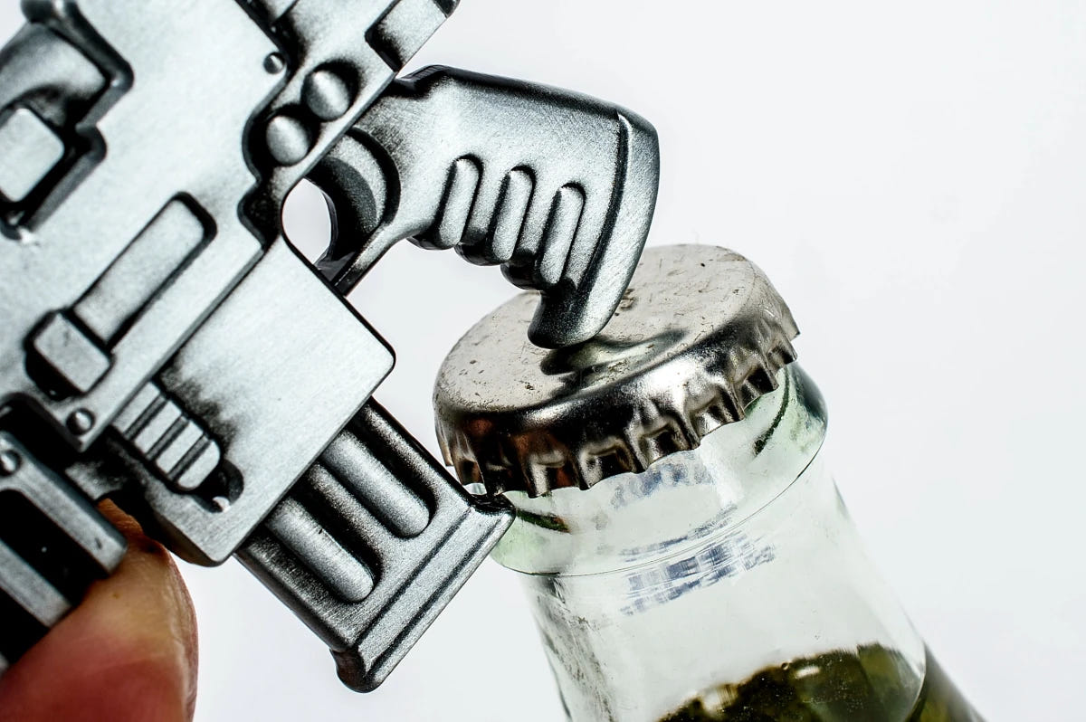 Warhammer 40,000 Bolt Rifle bottle opener levering the cap off a glass bottle