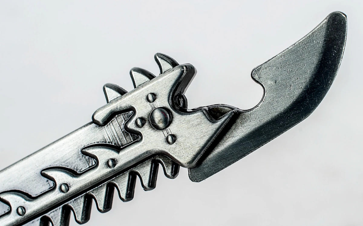 Close-up of the Chaos chainsword bottle opener's hooked tip and cap lifter