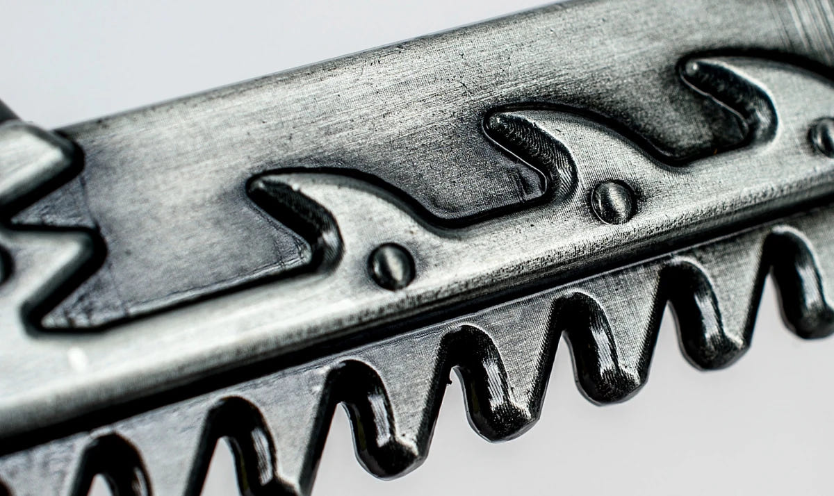 Close-up of the jagged chain teeth on the Warhammer 40,000 Chaos chainsword bottle opener