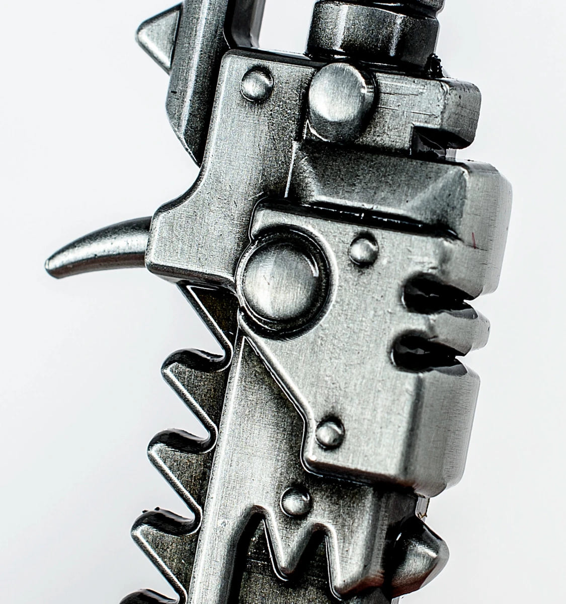 Vertical close-up of the hilt and spike on the Warhammer 40,000 Chaos chainsword bottle opener