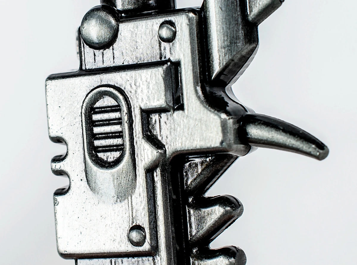 Close-up of the metal hilt detail on the Warhammer 40,000 Chaos chainsword bottle opener