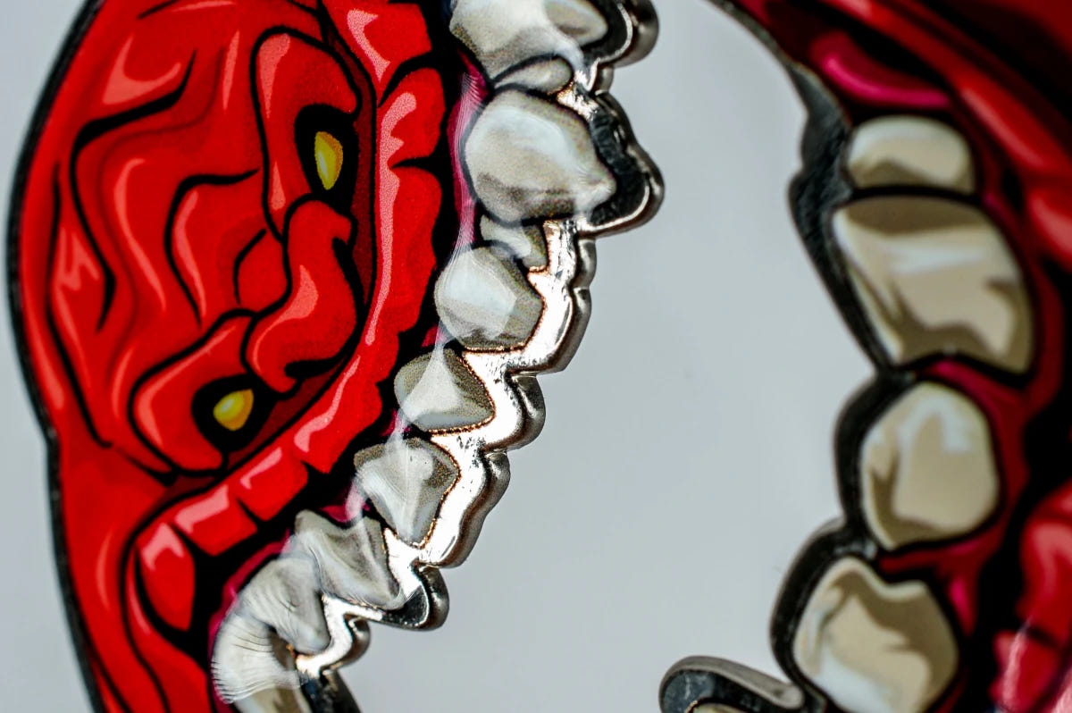Angled close-up of the Squig bottle opener's face and metal-edged teeth