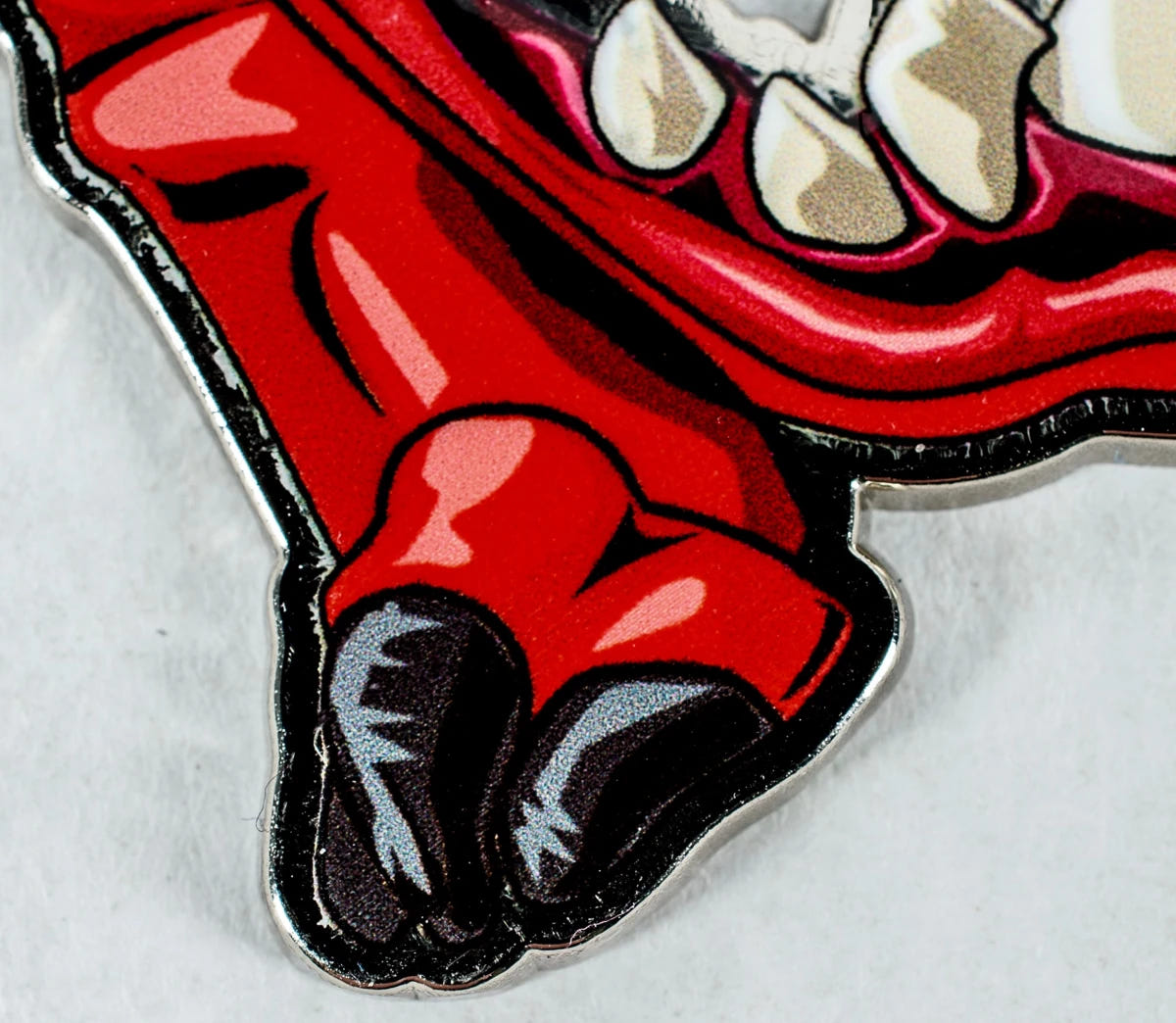 Close-up of the Squig bottle opener's painted red feet and black claws