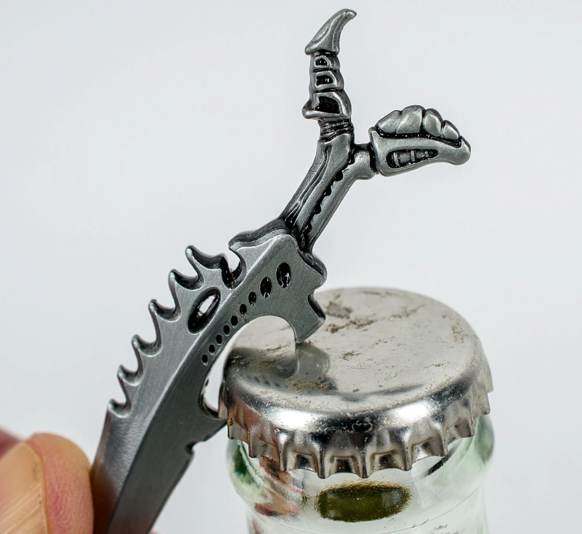 Tyranid Bonesword bottle opener lifting the cap off a glass bottle