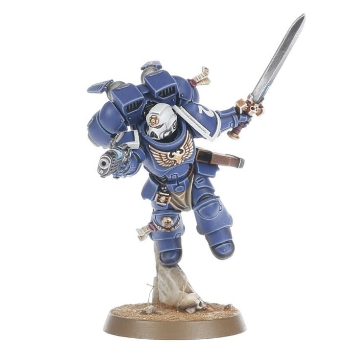 A painted miniature figurine of a space marine soldier in blue armor, holding a sword and standing on a round base against a plain white background.