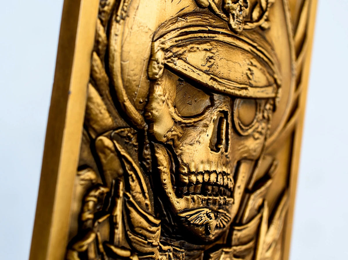 Close-up of Commissar Yarrick's skull-faced relief on the Warhammer 40,000 ingot, angled view