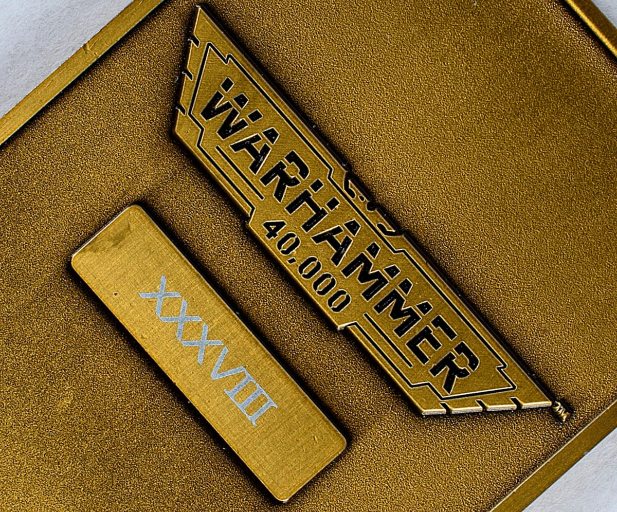 Close-up of the Warhammer 40,000 logo and edition number plate on the back of the Emperor ingot