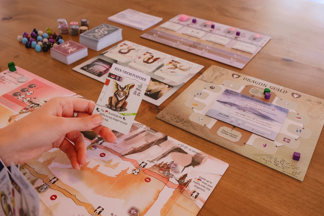 Player holding a Wyrmspan dragon card over a player mat during a game