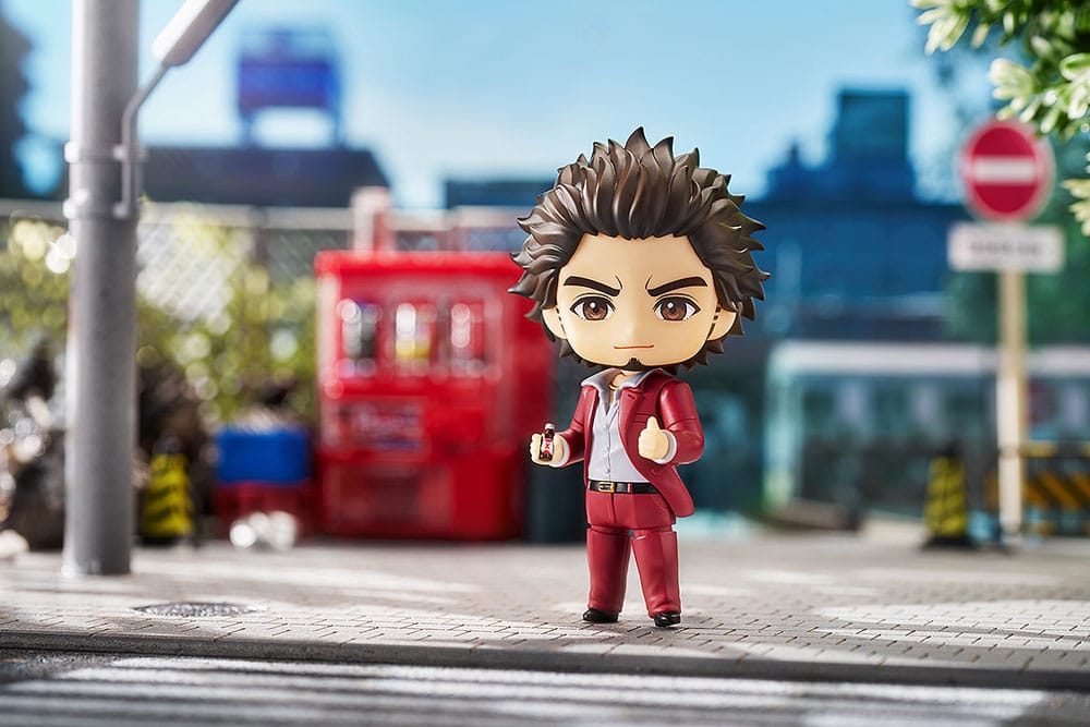 Ichiban Kasuga Nendoroid standing on a sunny pavement beside a red vending machine