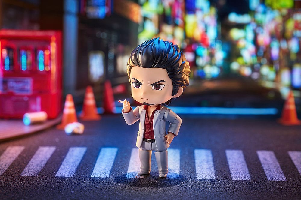 Kazuma Kiryu Nendoroid on a night-time zebra crossing with cones and neon signs